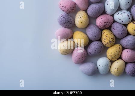 Colorful speckled mini Easter eggs on a plain back ground shot from above, flat lay Stock Photo