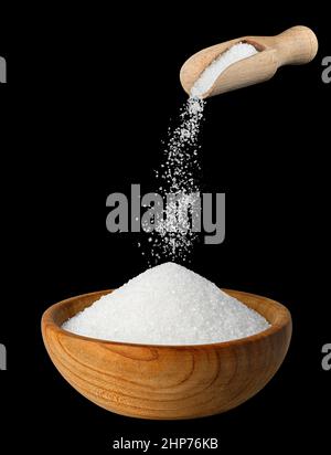 sugar falling from scoop in wooden bowl Stock Photo