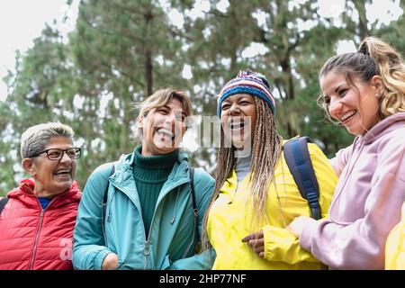 Group of women with different ages and ethnicities having fun walking in the woods - Adventure and travel people concept Stock Photo