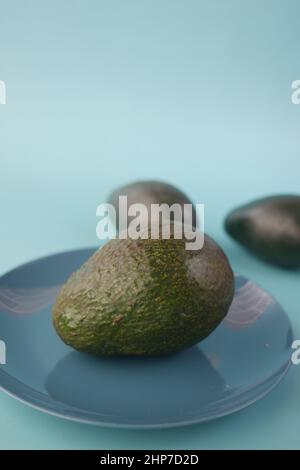 slice of avocado on a plate on light green background  Stock Photo