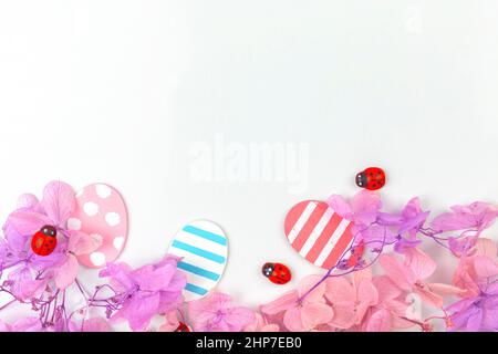 Colorful easter eggs and flowers. Bottom border design with pink spring flowers. Happy easter greetings concept, holiday decoration background with co Stock Photo