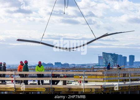 Wien, Vienna: reinforcement steel hanging on crane hook, construction workers standing on  top of formwork roof of a apartment house in construction, Stock Photo