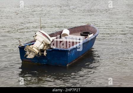 Empty and old fishing boat with engine moored on the blue sea Stock Photo -  Alamy