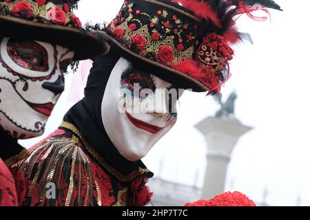 Masked revellers pose in St Mark's Square on February 20, 2022 in ...