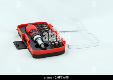 Metal screwdriver and a set of bits in a case. Photo on a white background. Stock Photo