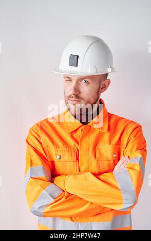 Attractive caucasian bearded construction site manager, supervisor or foreman in white hard hat and safety orange reflective vest. 1st of May or International Labor Day concept. High quality photo Stock Photo