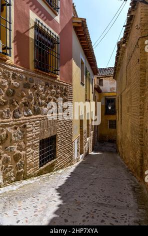 Old Town Alley - A wide-angle vertical view of a narrow and steep alleyway in the historic city Toledo on a sunny Autumn afternoon. Toledo, Spain. Stock Photo