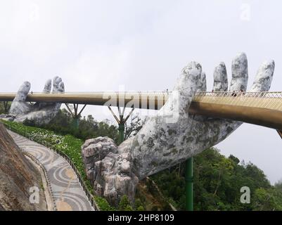 Da Nang, Vietnam - April 12, 2021: Golden Bridge lifted by giant hands in Ba Na Hills, a famous theme park and resort in Central Vietnam Stock Photo