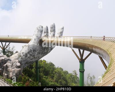 Da Nang, Vietnam - April 12, 2021: Golden Bridge lifted by giant hands in Ba Na Hills, a famous theme park and resort in Central Vietnam Stock Photo