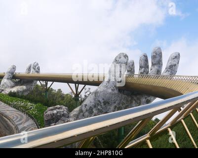 Da Nang, Vietnam - April 12, 2021: Golden Bridge lifted by giant hands in Ba Na Hills, a famous theme park and resort in Central Vietnam Stock Photo