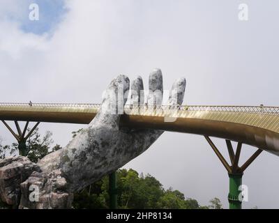 Da Nang, Vietnam - April 12, 2021: Golden Bridge lifted by giant hands in Ba Na Hills, a famous theme park and resort in Central Vietnam Stock Photo