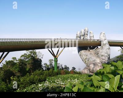 Da Nang, Vietnam - April 12, 2021: Golden Bridge lifted by giant hands in Ba Na Hills, a famous theme park and resort in Central Vietnam Stock Photo