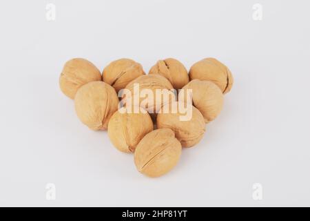 Walnuts are lined with a triangle on a white background in the form of an arrow or billiard balls Stock Photo