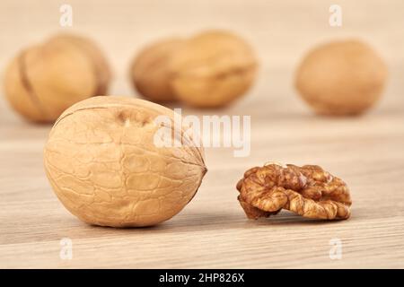 Whole walnut together with peeled walnut on a wooden background Stock Photo