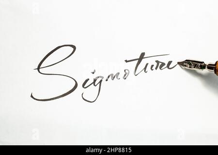 Signature word handwritten with a dip pen on white paper Stock Photo
