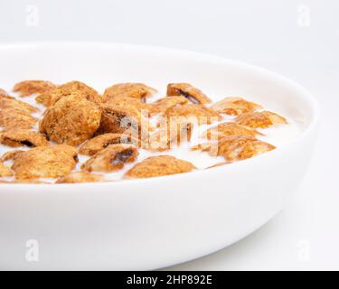 Crispy pads chocolate pillows with milk in dish isolated on the white background Stock Photo