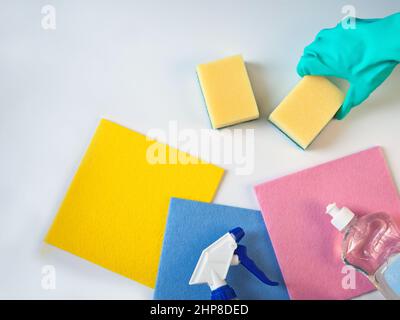 hand in glowes. Household chemicals in bottles, rag and sponge for cleaning. Dishwashing products. Stock Photo