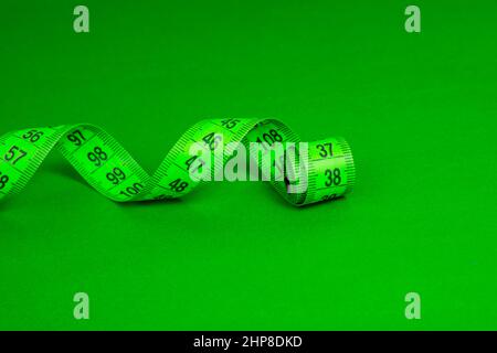 Colorful spiral tape measure on color background with space for text Stock Photo
