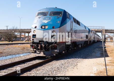 Taylor, Texas USA - passenger railroad Amtrak train Texas Eagle diesel locomotive pulling several passenger coaches arriving at passenger station Stock Photo