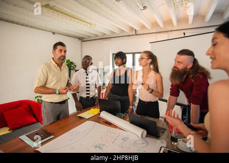 Group of multi racial co workers are having a serious talk about the new project Stock Photo