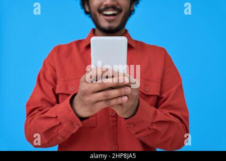 Happy young man using cell phone isolated on blue background. closeup Stock Photo
