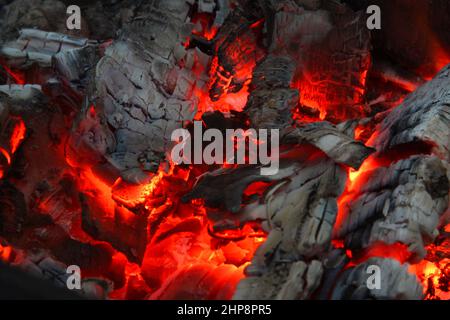 Smoldered logs burned in vivid fire close up. Atmospheric background with flame. Background from a fire Stock Photo