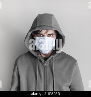 Man in medical mask and hoodie. Coronavirus protection concept. Stock Photo