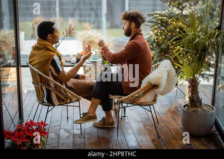 Two male friends celebrating winter holidays at backyard Stock Photo
