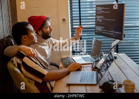 Gay couple working on computers at home office Stock Photo