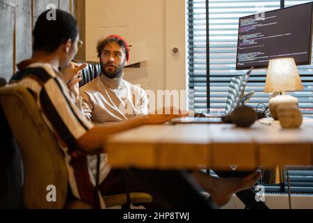 Two men working on computer at home office Stock Photo