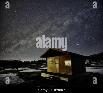 nightscape mountain wooden hut milky way dark sky Stock Photo