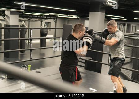 RUSSIA, MOSCOW - FEB 14, 2022: boxing training gym young gloves, for strength kickboxing in competition from power aggression, muscle background Stock Photo