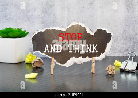 text Stop and Think on white paper. Stock Photo