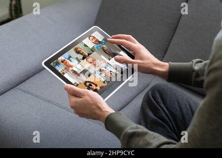 Remote Work Communication. Businesswoman Holding Tablet Having Online Meeting With Group Of Coworkers Making Video Call Via Computer Sitting In Modern Stock Photo