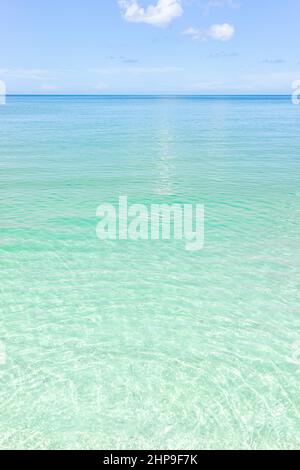 Naples beach in Southwest Florida with turquoise glass green idyllic water on sunny day with blue sky coast horizon in paradise, nobody in vertical vi Stock Photo