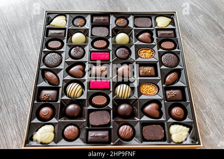 Open box of chocolates truffles with luxury gourmet milk and dark desserts package closeup with different shapes variety Stock Photo