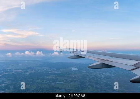 Airplane flying pov from window aerial view of Ft Myers city houses buildings and farm fields with Saharan dust plume in southwest Florida USA morning Stock Photo