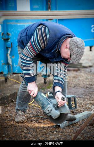 man cutting metal with electric disc cutter Stock Photo