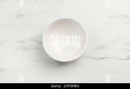 empty white bowl on marble texture kitchen table, top view Stock Photo
