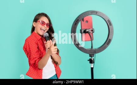 cheerful kid music blogger. karaoke. child singing song. vlogger with microphone. Stock Photo