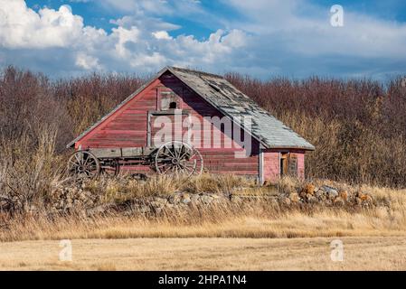 An antique horse-drawn cart in front of an old granary on the Saskatchewan prairies Stock Photo