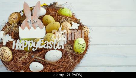 Easter eggs in the basket of wooden boards. yellow chicks on a  wooden background. The minimal concept. An Easter card with a copy of the place for th Stock Photo