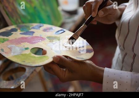 Close up focus on palette with mixed paints. Stock Photo