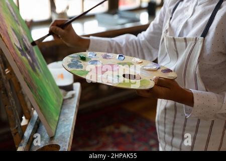 Close up cropped young male artist painting on canvas. Stock Photo