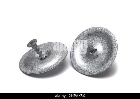 Close up of two silver galvanized metal plates with wood screws for fixing bitumen sheeting on roofs and on wooden substrates on white background seen Stock Photo