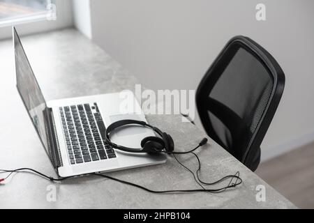 Open blank laptop in modern workplace with office supplies and decorations on white table Stock Photo