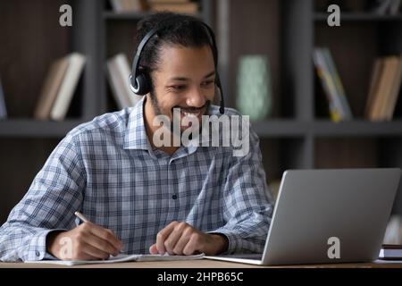 Happy young African American man e-learning using computer. Stock Photo