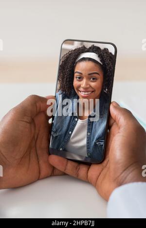 Unrecognizable black man using smartphone, having video call with girlfriend Stock Photo
