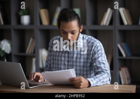 Focused smart 30s millennial African American businessman working with documents. Stock Photo