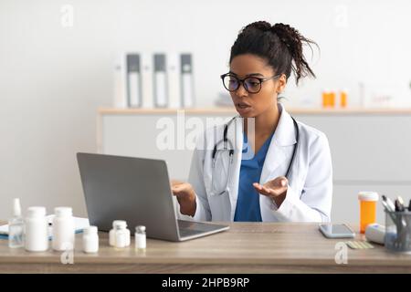 Portrait of black female medical practitioner using laptop Stock Photo